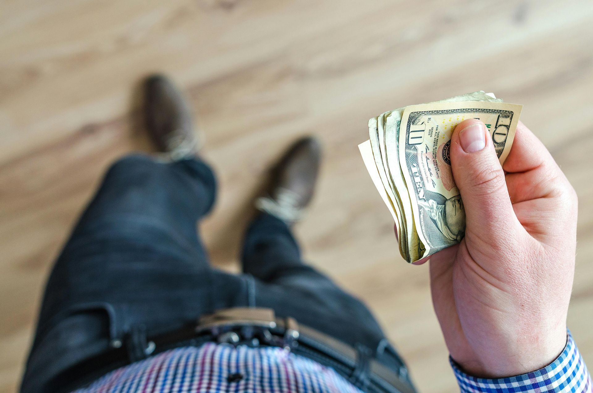 A man is holding a stack of money in his hand.