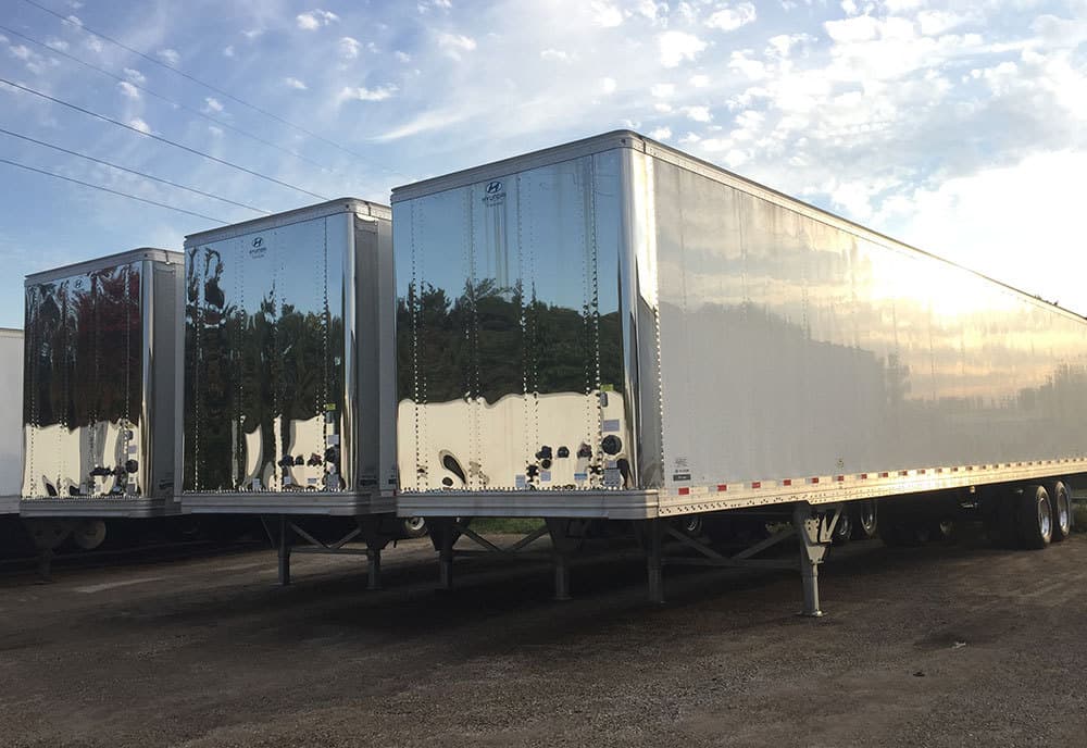 A row of trailers are parked next to each other in a parking lot.