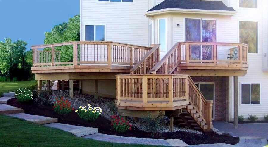 Curved wooden garden deck with railing planters and steps beside a house