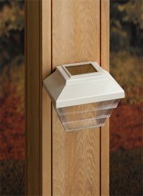 White outdoor wall light mounted on a wooden post, with a clear glass bottom.