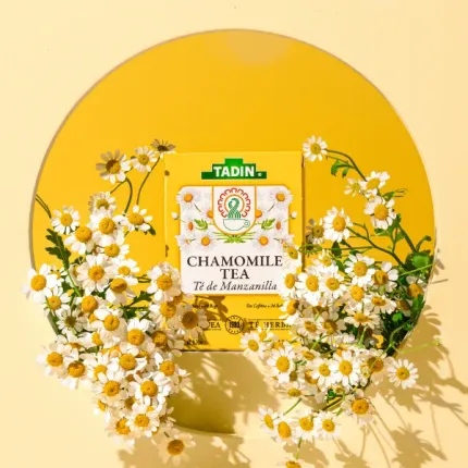 A box of chamomile tea is surrounded by daisies