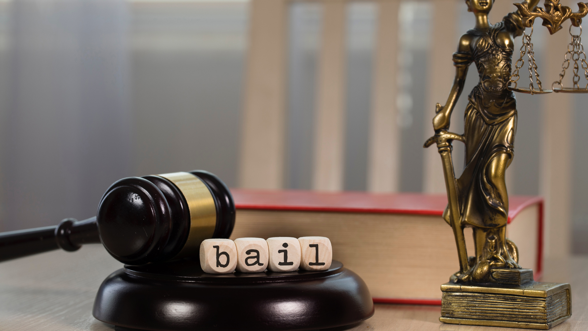 Gavel, “bail” blocks, and Lady Justice statue on a desk