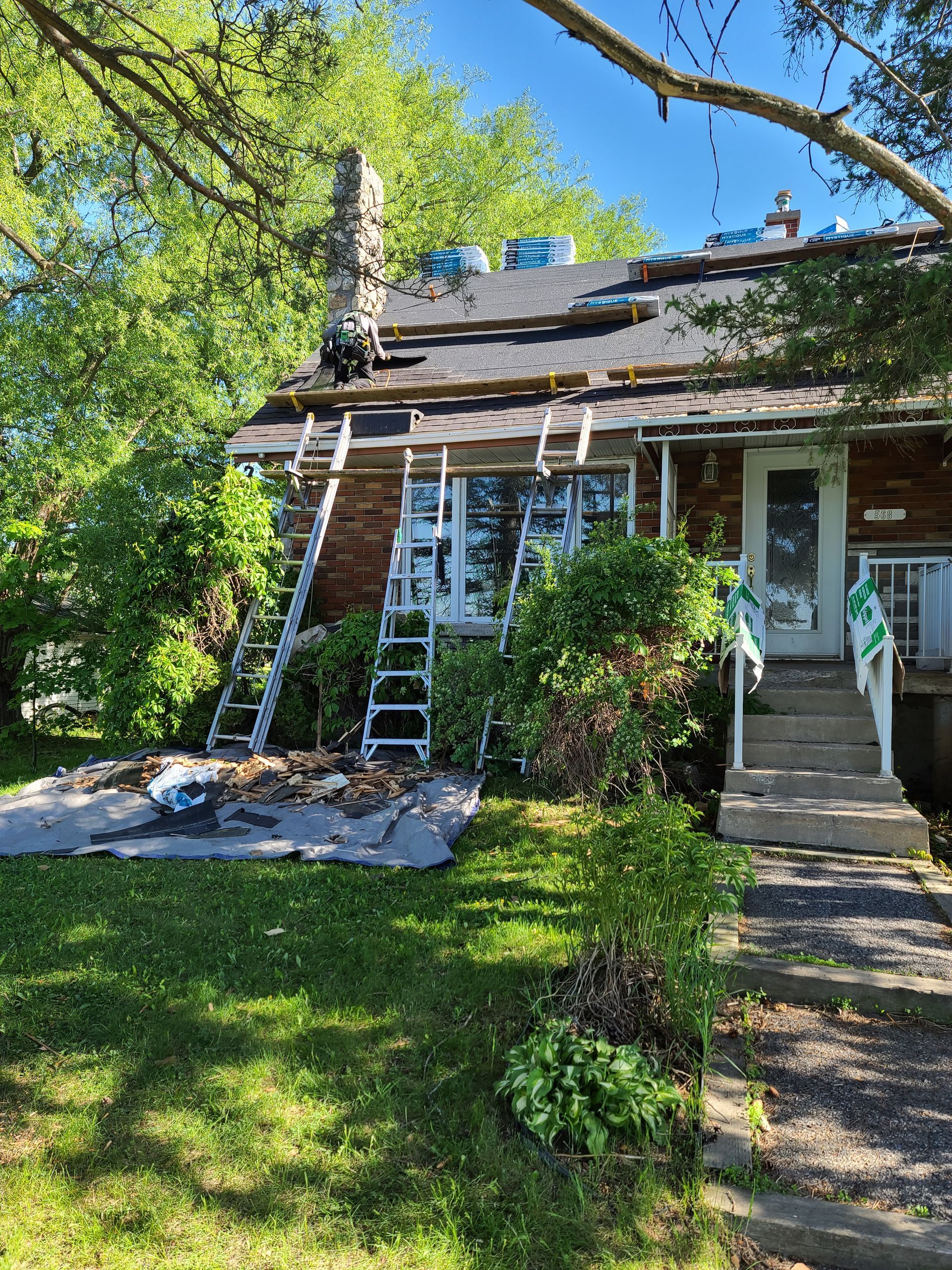 A house with a ladder on the front of it is being remodeled.
