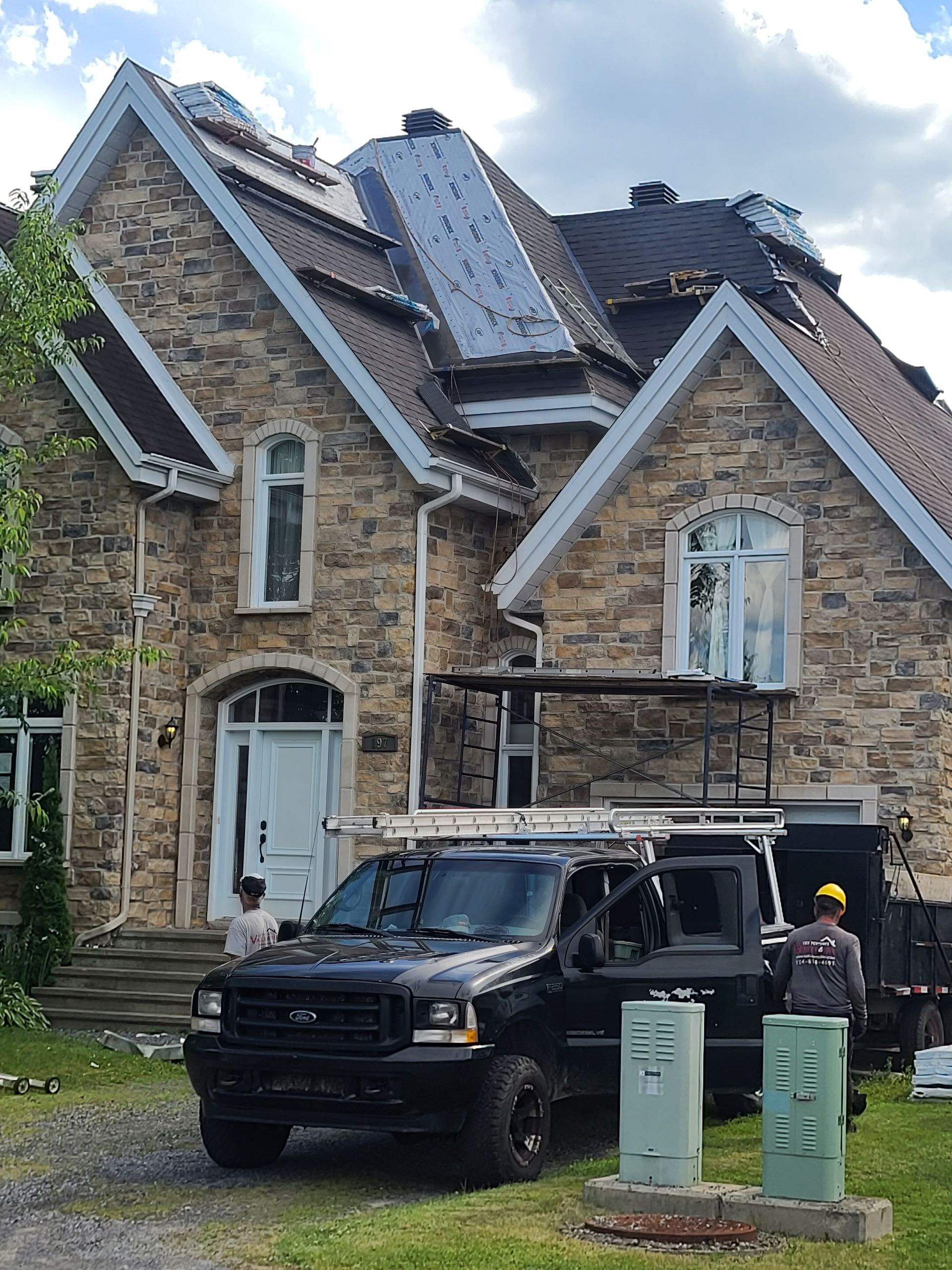 A truck is parked in front of a large brick house.