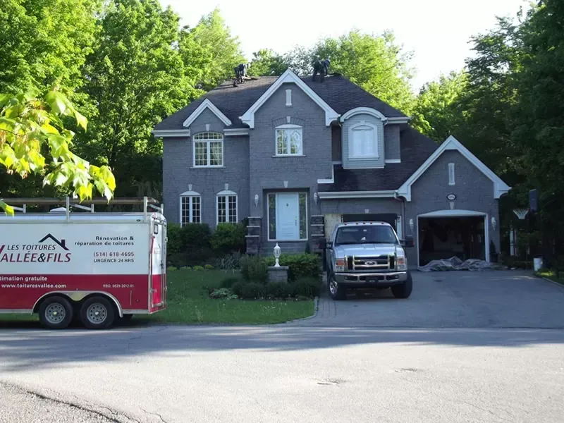 Un camion Ford est garé devant une grande maison