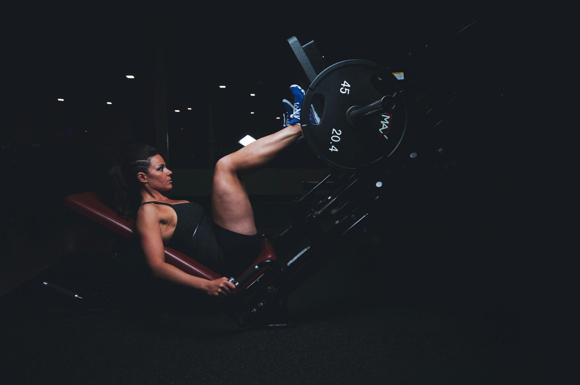 Een vrouw gebruikt een leg press-machine in de sportschool.