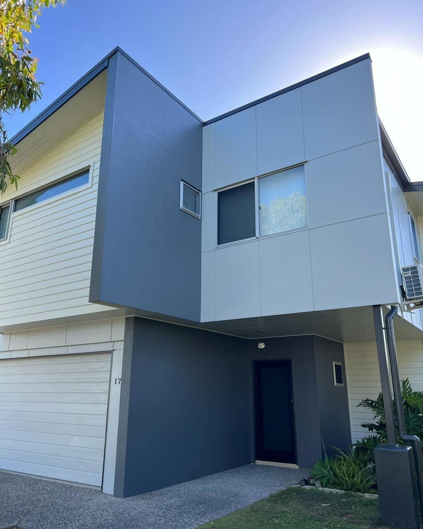 A Large House with A Lot of Windows and A Garage — Darren Smith Painting Pty Ltd in Sarina, QLD