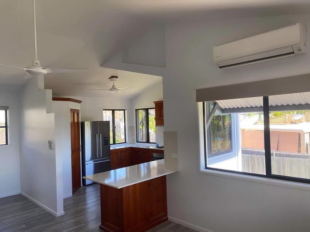 An Empty Kitchen with A Refrigerator and A Ceiling Fan — Darren Smith Painting Pty Ltd in Mirani, QLD