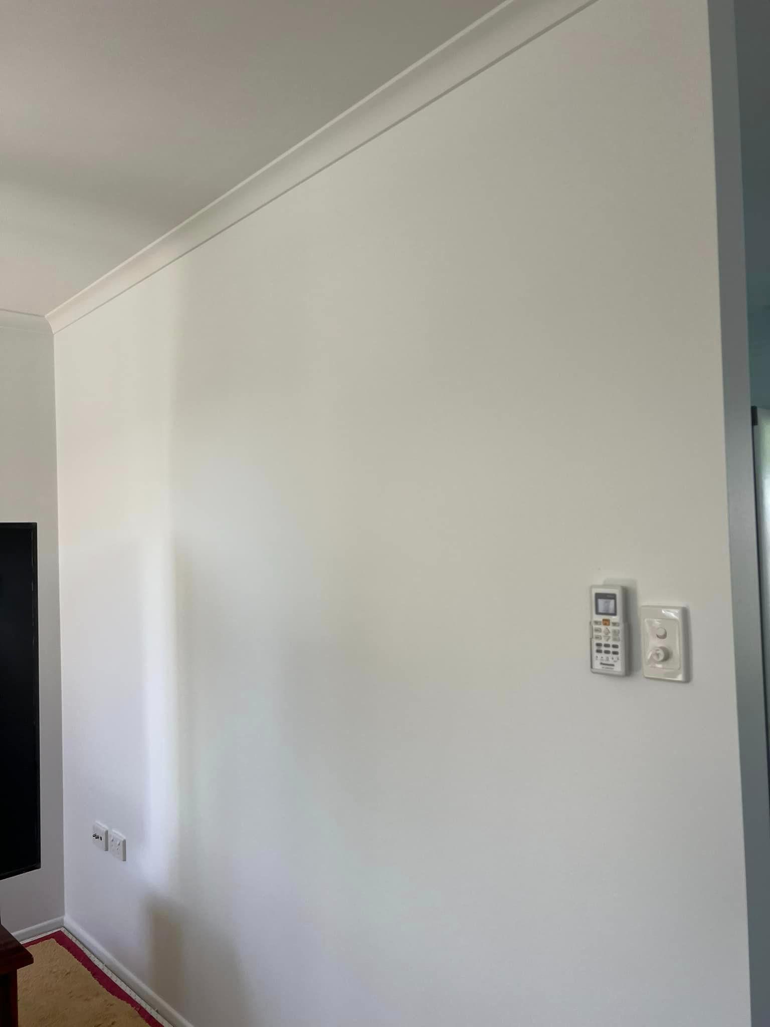 A White Wall with A Remote Control on It in A Living Room — Darren Smith Painting Pty Ltd in Sarina, QLD
