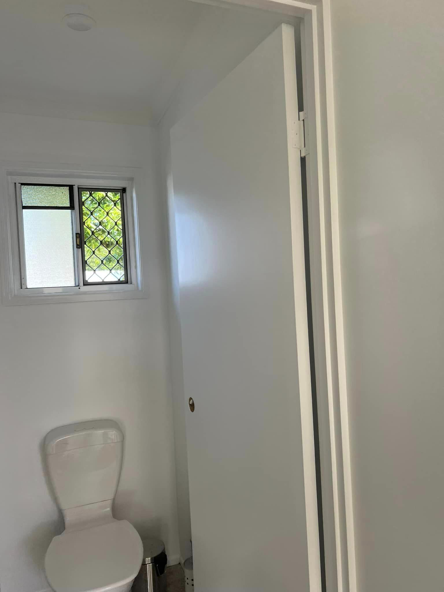 A Toilet Is Sitting in A Bathroom Next to A Window — Darren Smith Painting Pty Ltd in Mackay, QLD