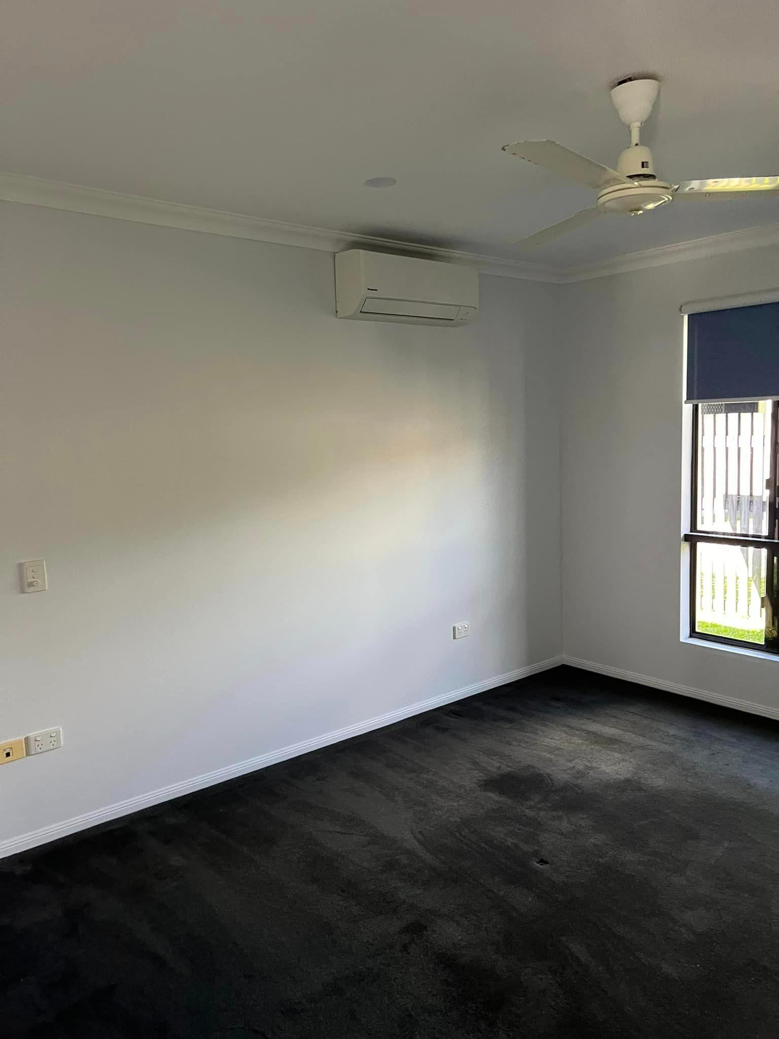 An Empty Room with A Ceiling Fan and A Window — Darren Smith Painting Pty Ltd in Sarina, QLD