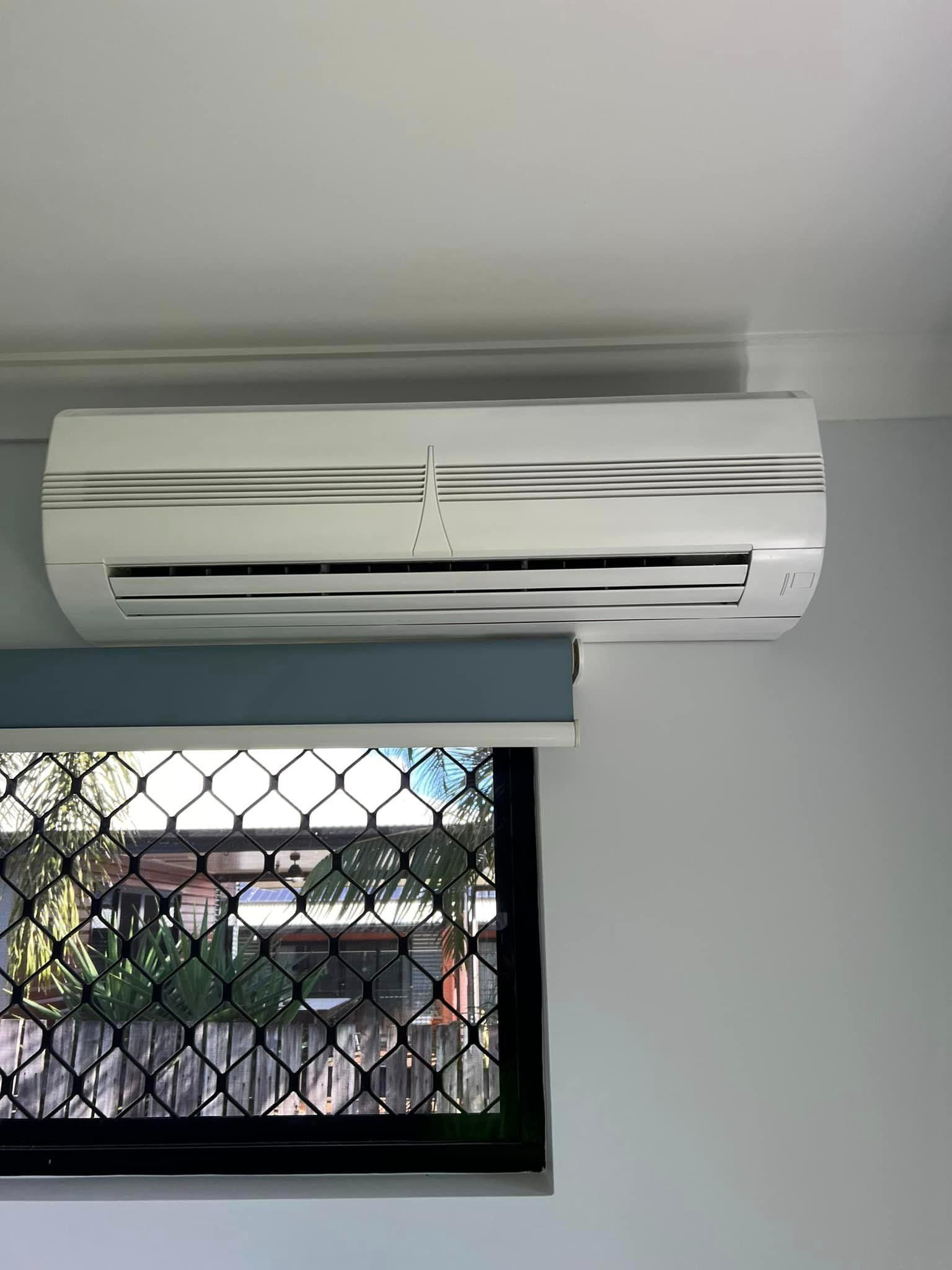 A White Air Conditioner Is Hanging from The Ceiling Next to A Window — Darren Smith Painting Pty Ltd in Northern Beaches, NSW