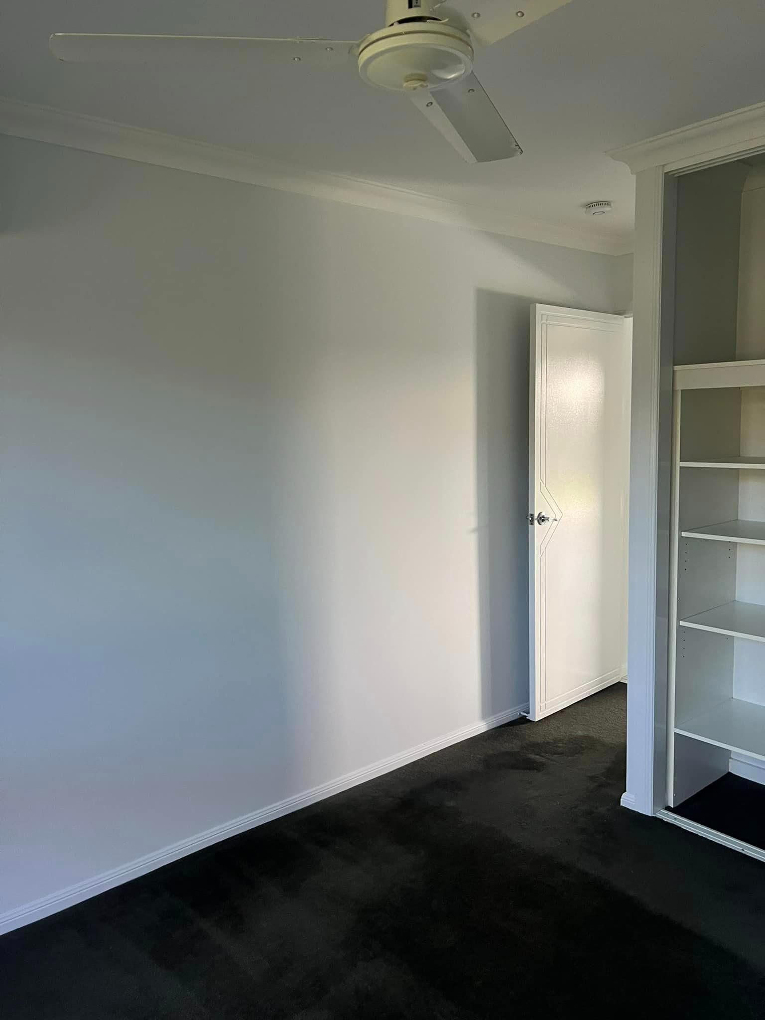 An Empty Room with A Ceiling Fan and A Door — Darren Smith Painting Pty Ltd in Rural View, QLD