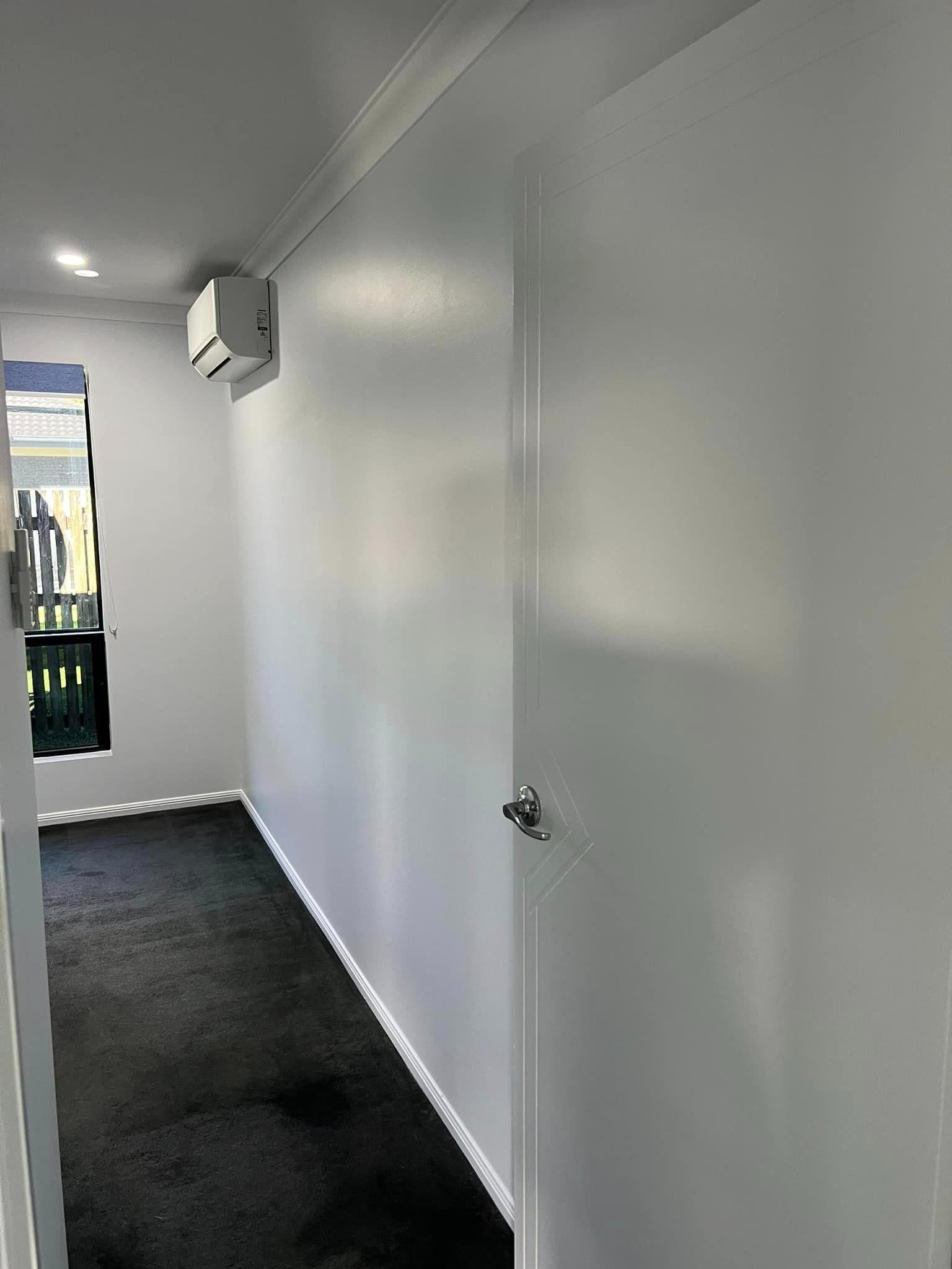 A Long Hallway with White Walls and A Black Carpet — Darren Smith Painting Pty Ltd in Rural View, QLD