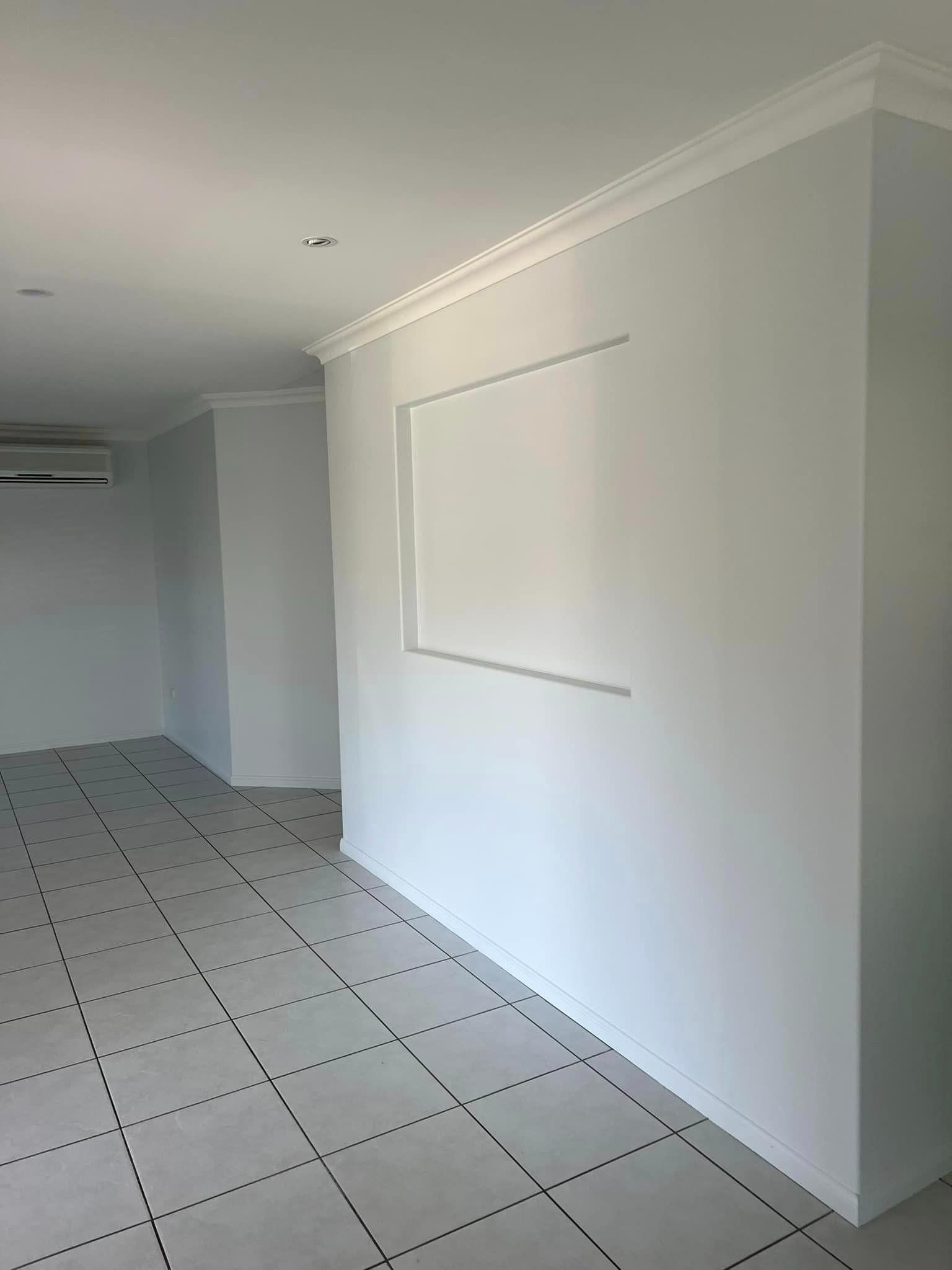 An Empty Living Room with White Tile Floors and White Walls — Darren Smith Painting Pty Ltd in Rural View, QLD