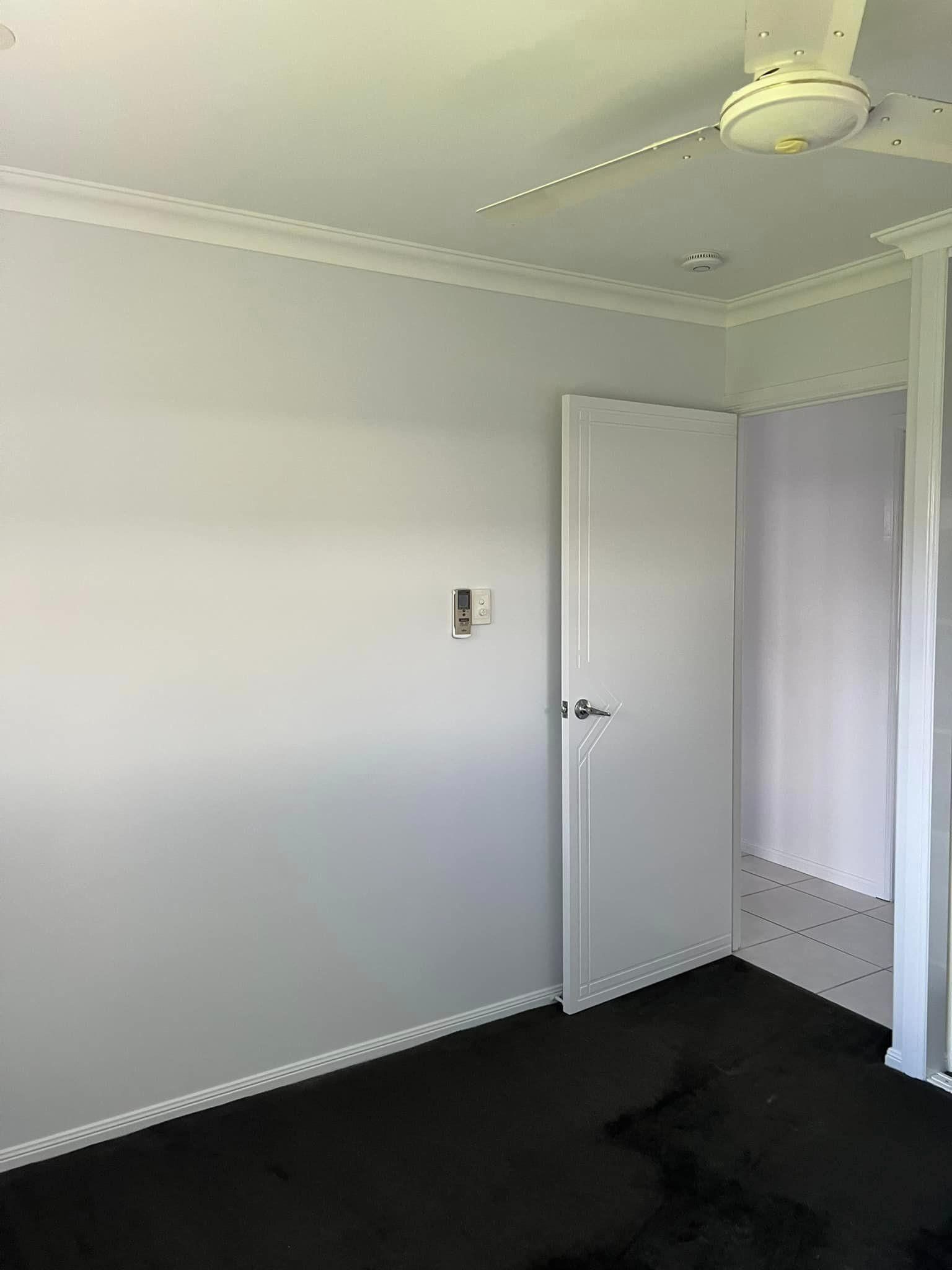 A Bedroom with A Ceiling Fan and A Door — Darren Smith Painting Pty Ltd in Sarina, QLD