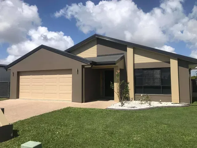 A House with Two Garage Doors and A Large Lawn in Front of It — Darren Smith Painting Pty Ltd in Sarina, QLD