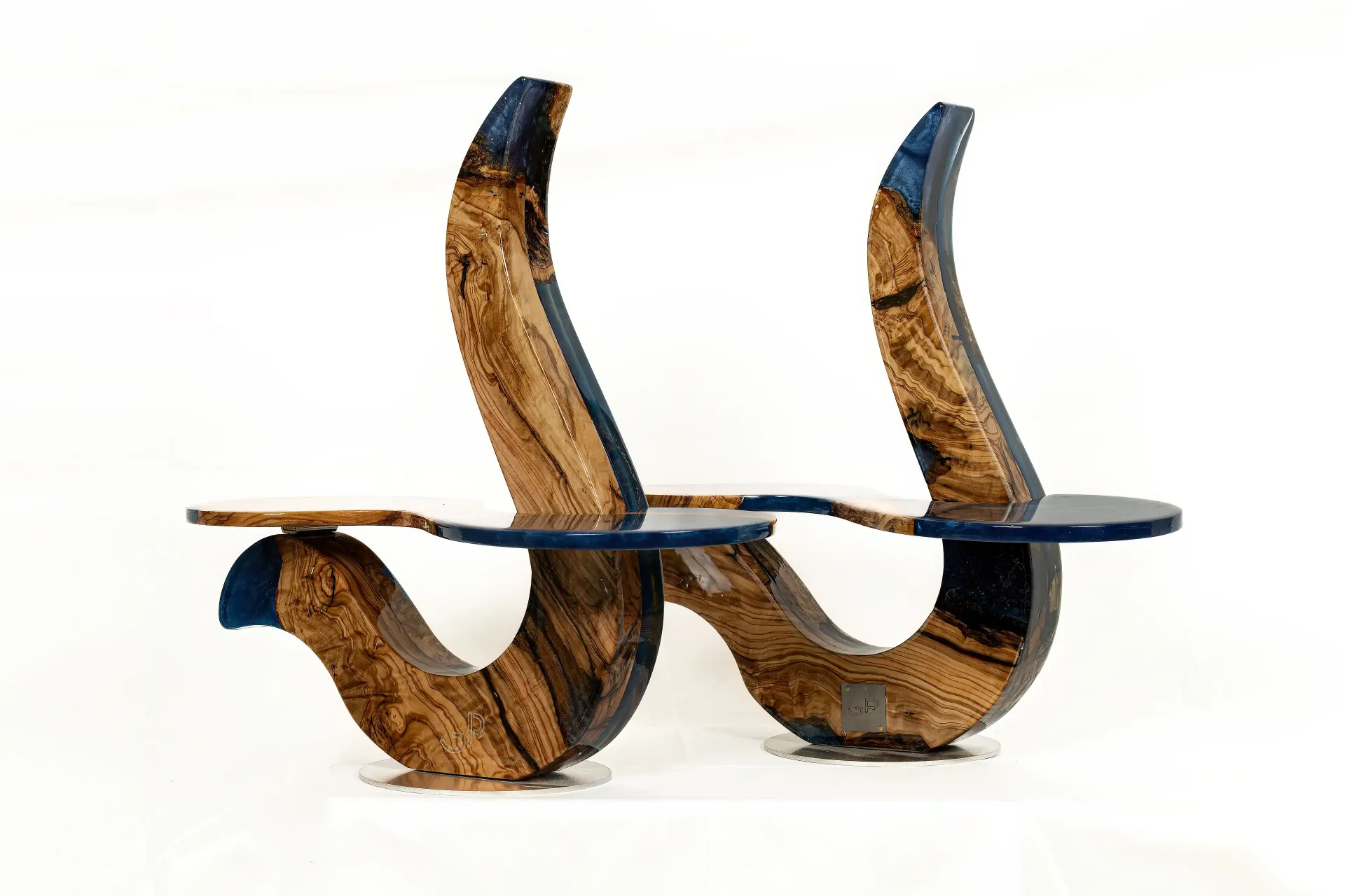 Coppia di portapiatti scultorei, realizzati con struttura curva in legno naturale dalle venature marcate e pianali in resina epossidica con varie sfumature blu, effetto lucido. Opera funzionale di Guerino Rusconi.
