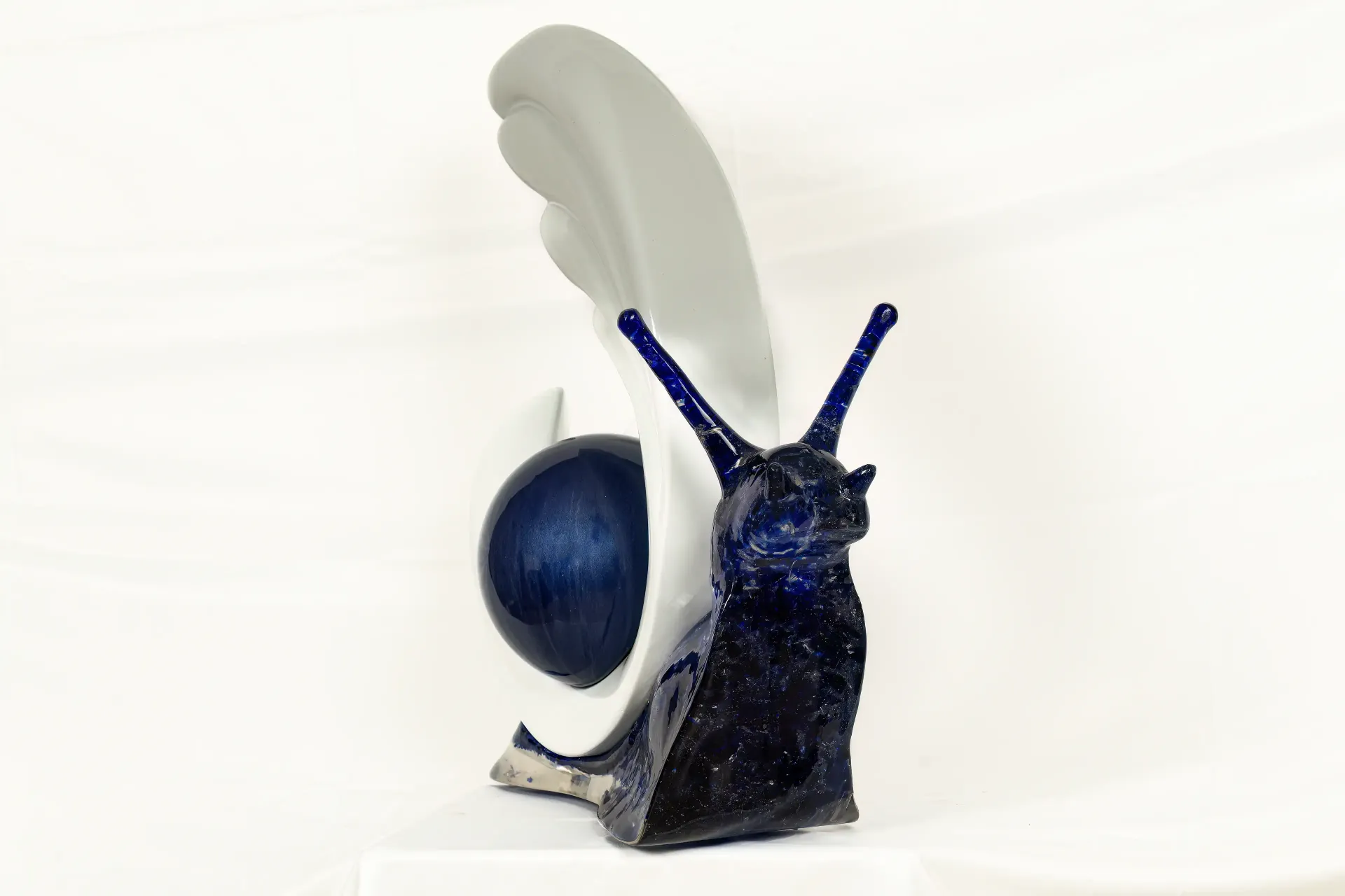 Scultura di chiocciola caratterizzata da un corpo in resina blu cobalto intenso, effetto marmoreo. Guscio a sfera e inserto in gesso ceramico. Opera di Guerino Rusconi.