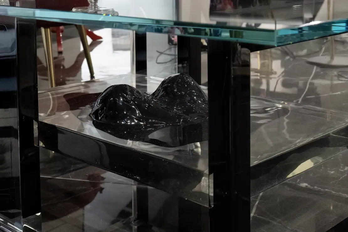 Tavolino di design in resina epossidica nera: inclusione artistica ispirata al corpo femminile Tavolino in resina epossidica con ripiano principale in vetro e ripiano inferiore con un'inclusione di una scultura tridimensionale astratta in gesso ceramico nero.