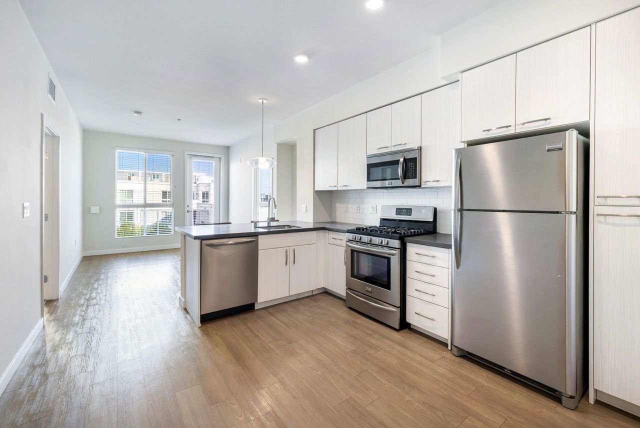 Bright kitchen with white cabinetry, stainless steel appliances, and an island.