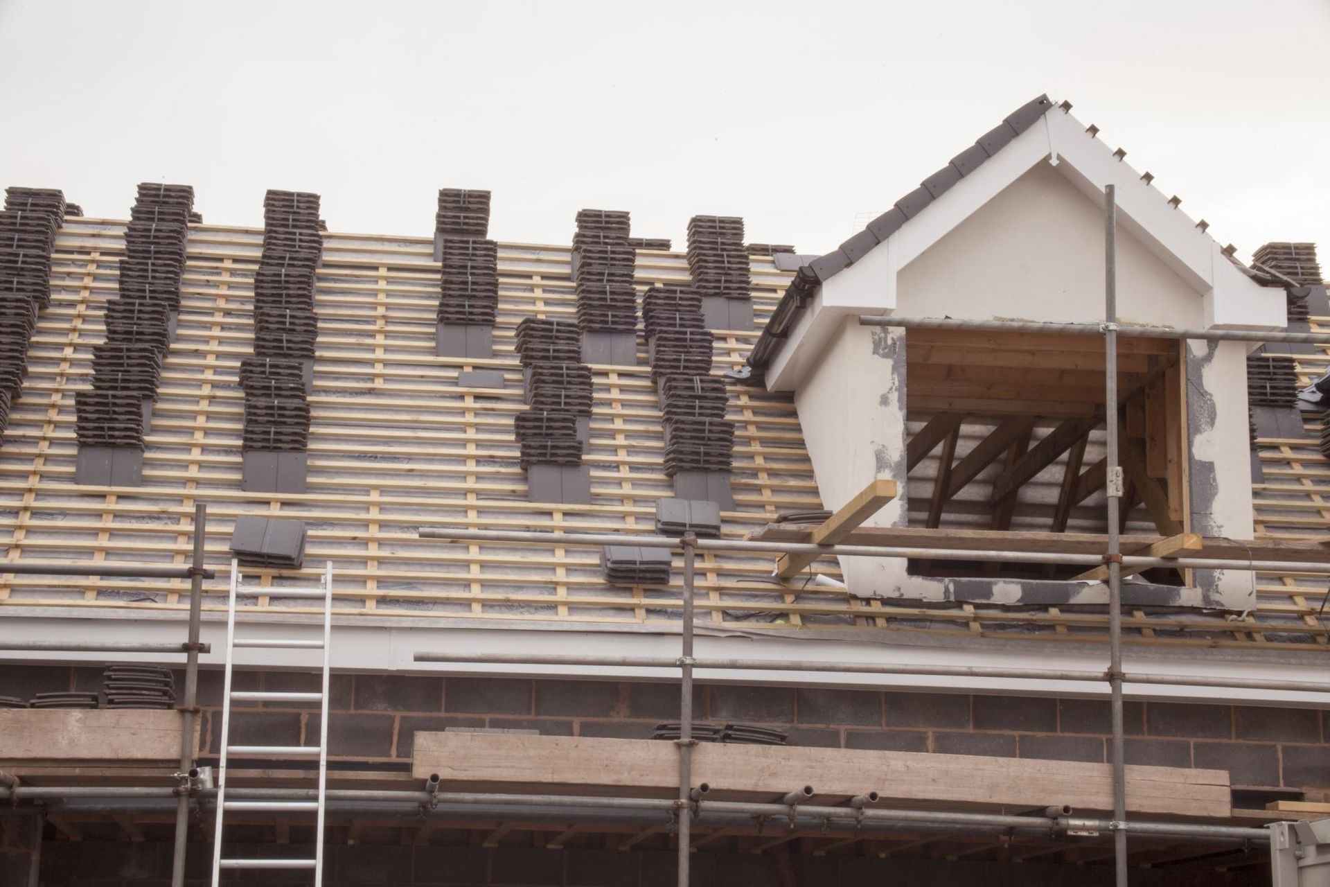A roof is being built with scaffolding and a ladder
