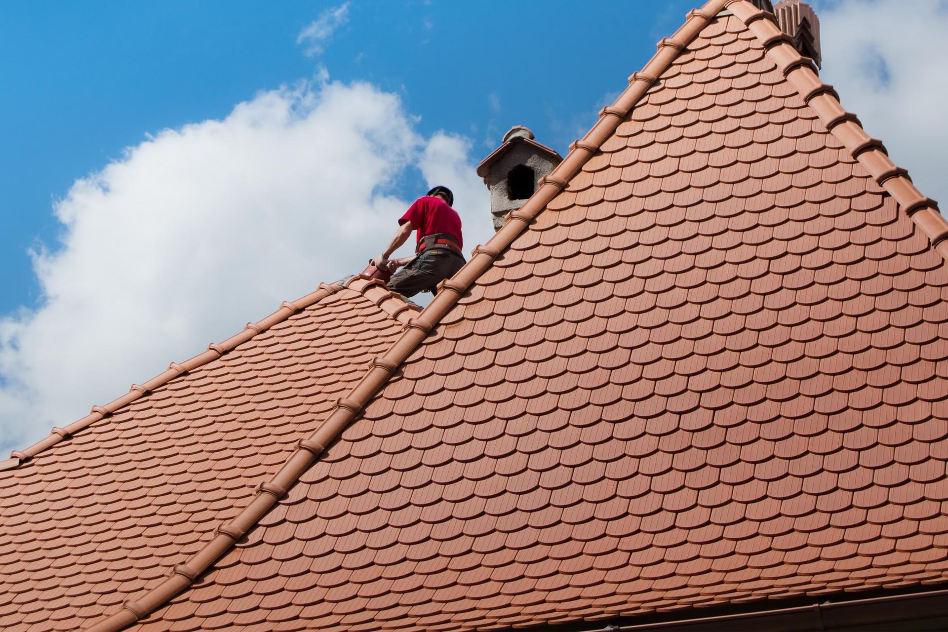 A man is working on the roof of a house