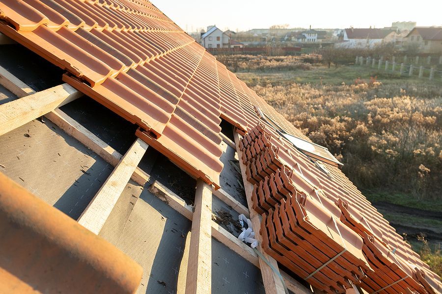 A roof that is being built with a lot of tiles on it
