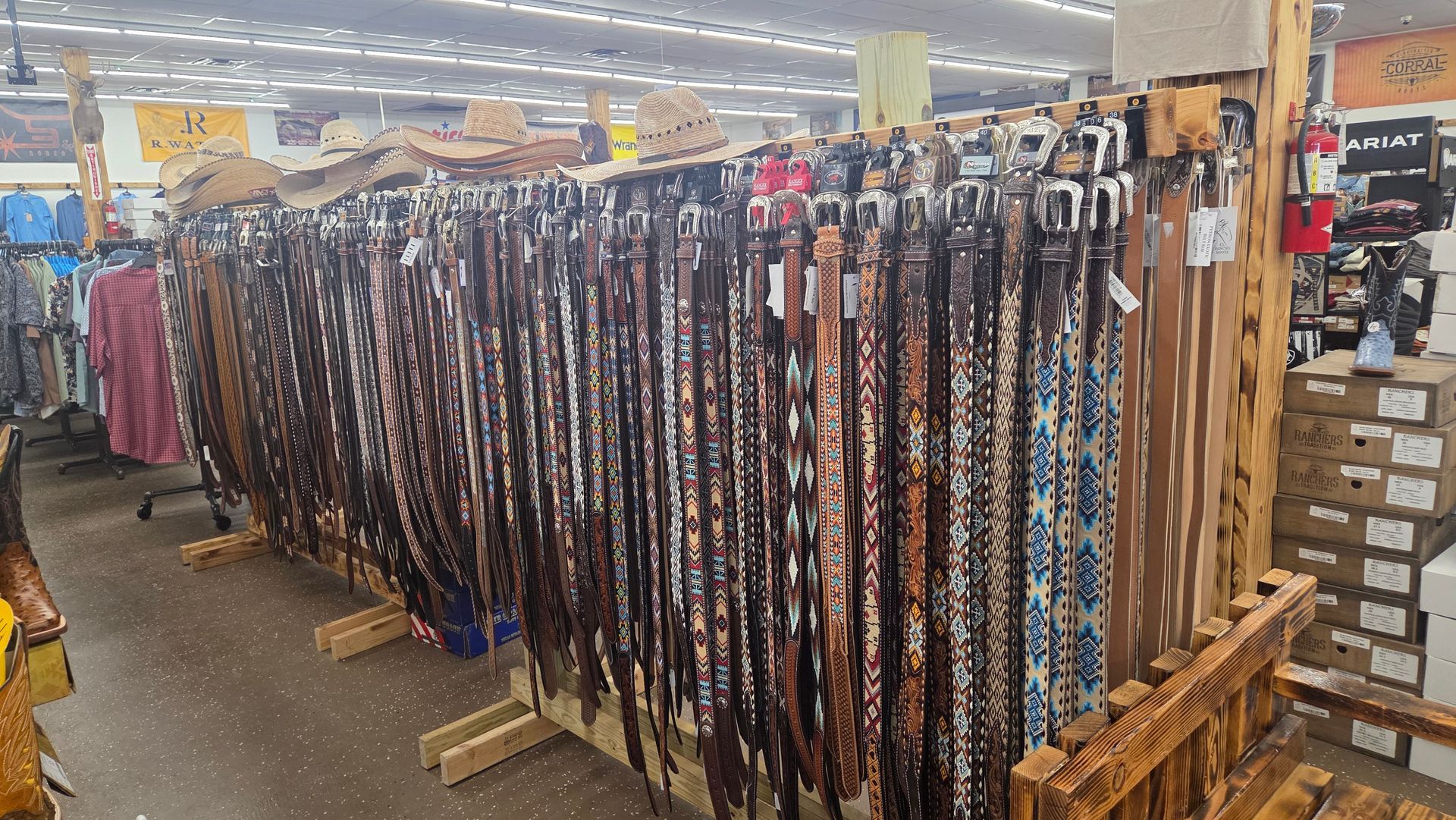 Store aisle with rows of hanging belts and straps in a retail setting