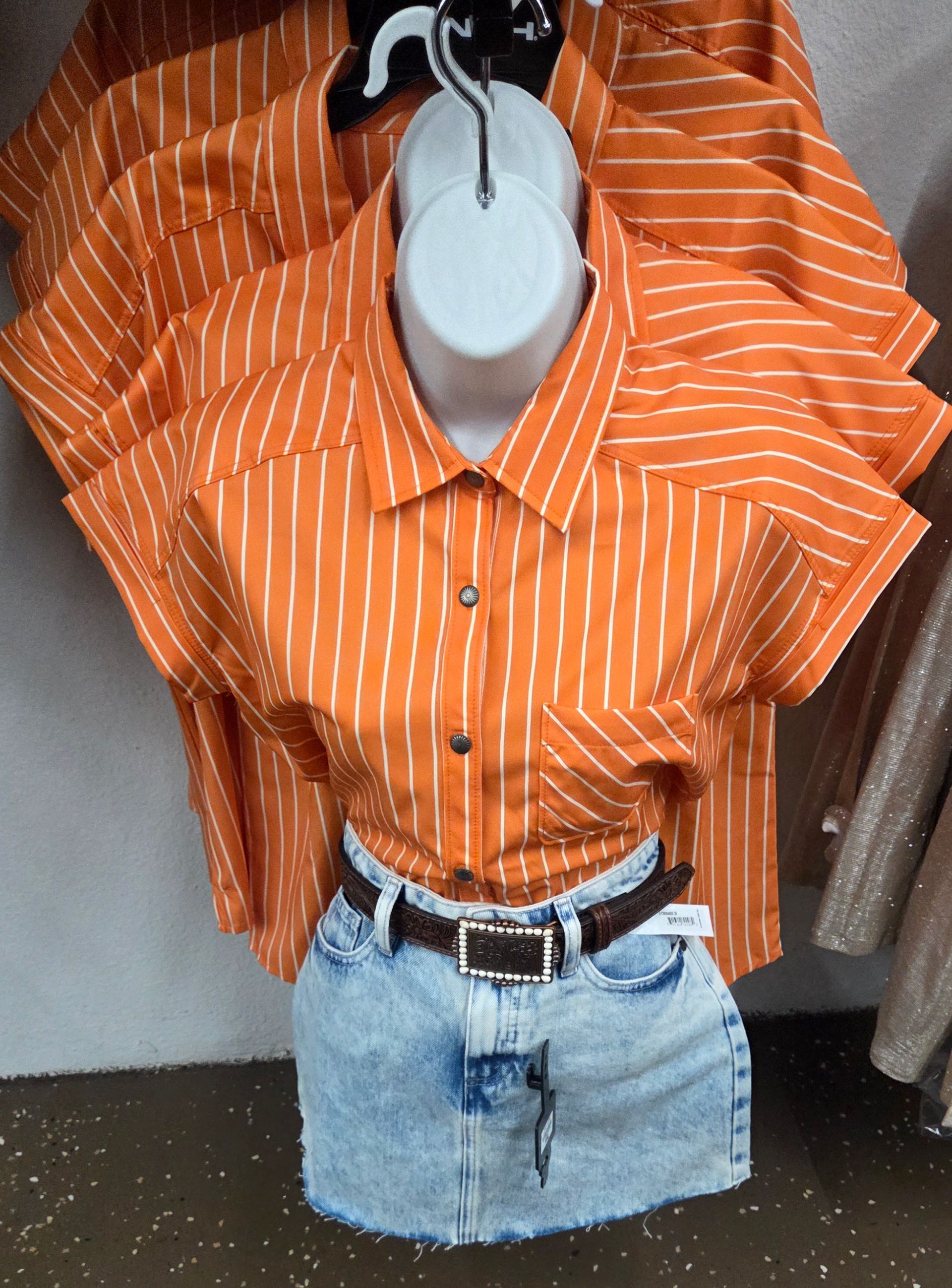 Orange striped shirt and denim skirt on a mannequin, displayed against a gray backdrop.