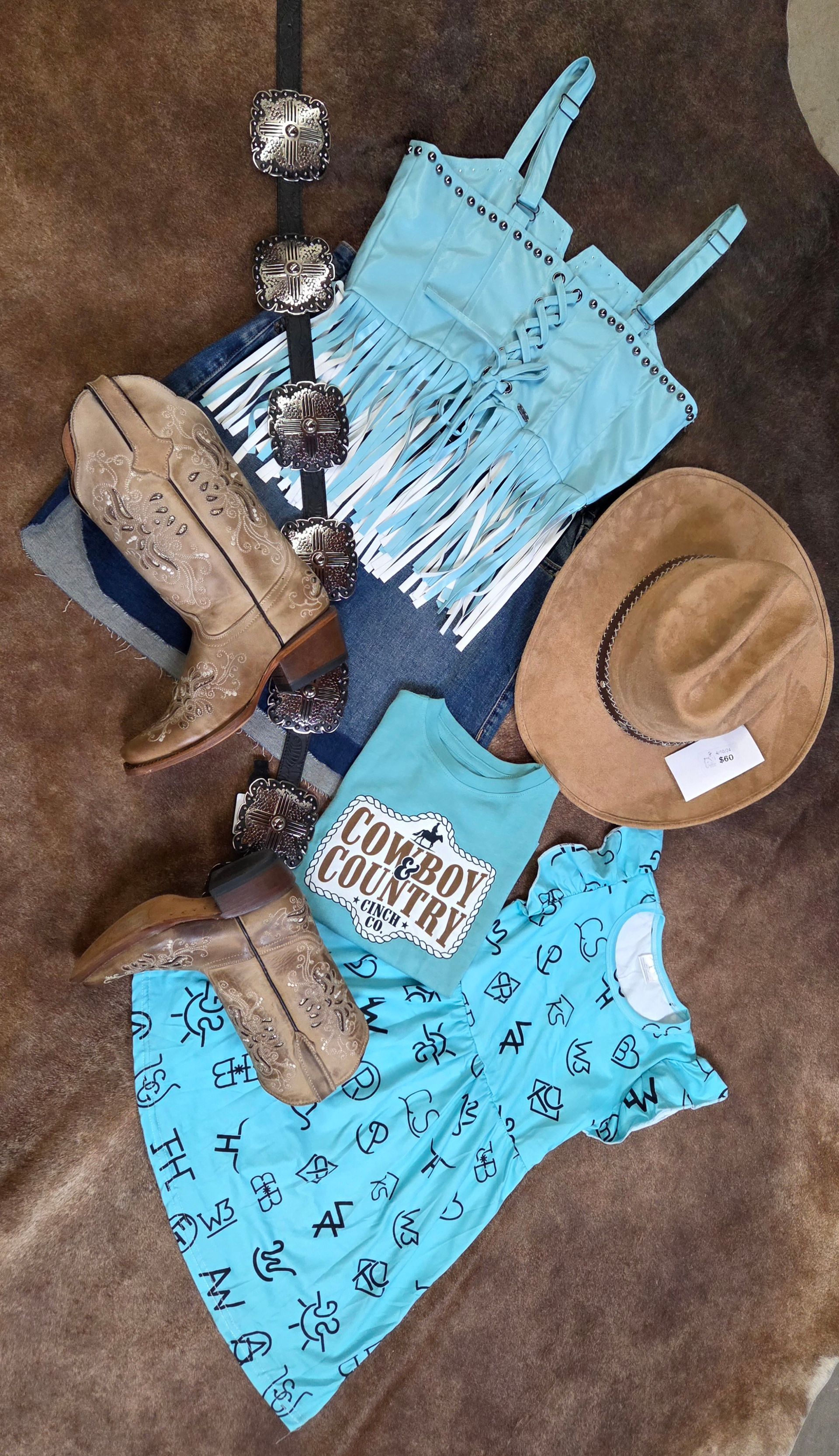Tan and blue outfit laid out on brown carpet with hat and accessories