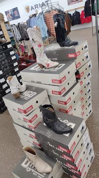 Stacked sneaker boxes in a store display, with multiple shoes perched on top.