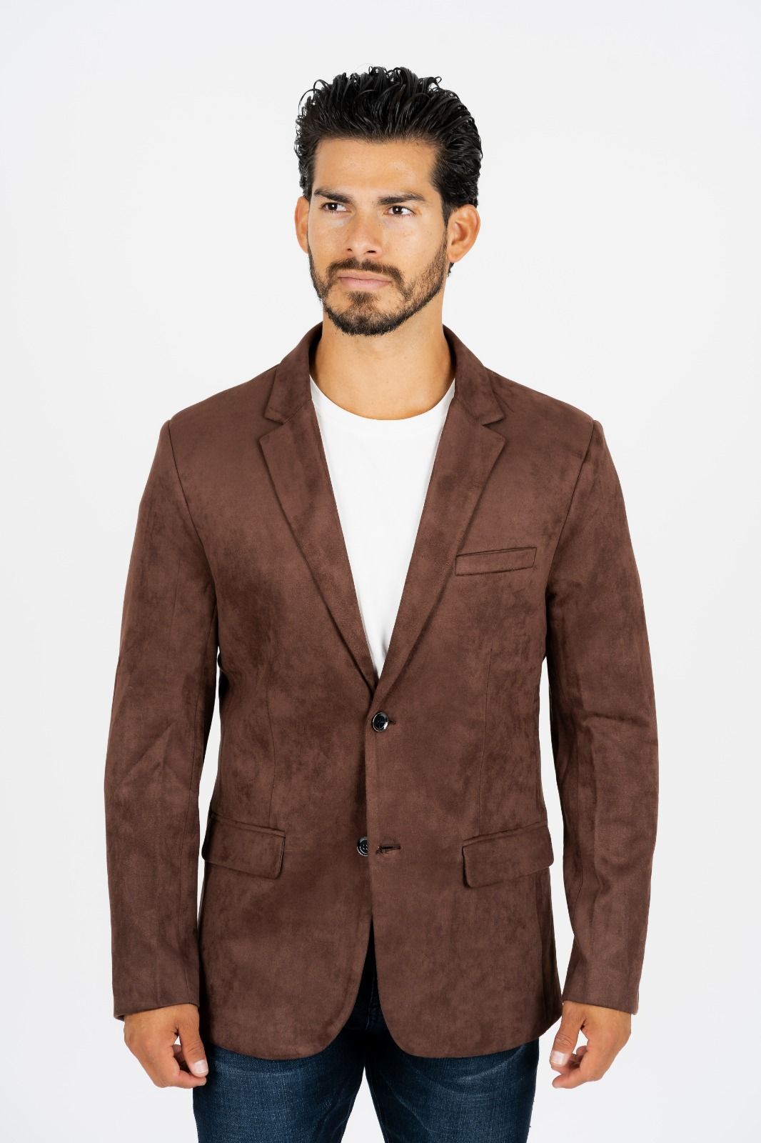 Man wearing a brown blazer over a white shirt, standing against a plain white background.