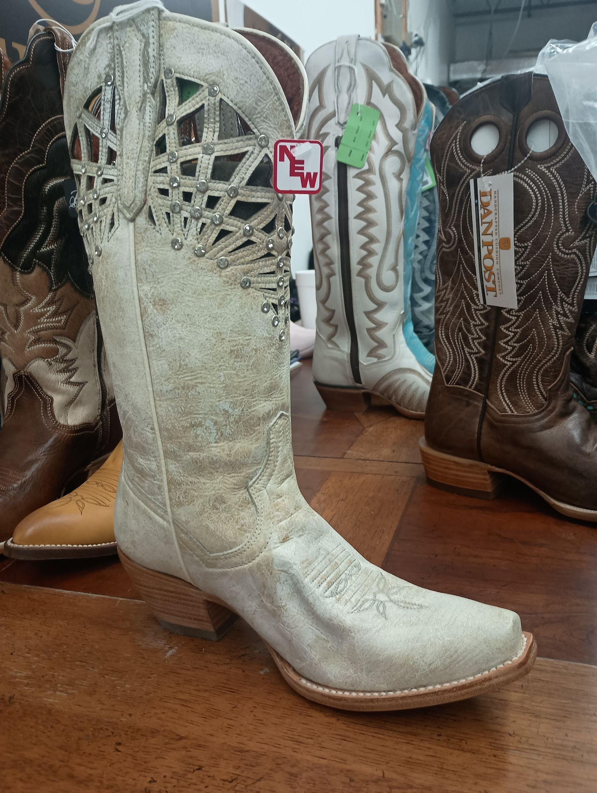 White fringed cowboy boot displayed in a shop, with other boots in the background