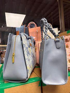 Two gray handbags on a shelf, one with a braided handle and one with a gold zipper tassel