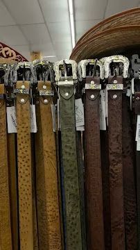 Row of decorative woven belts or straps hanging vertically on display in a store