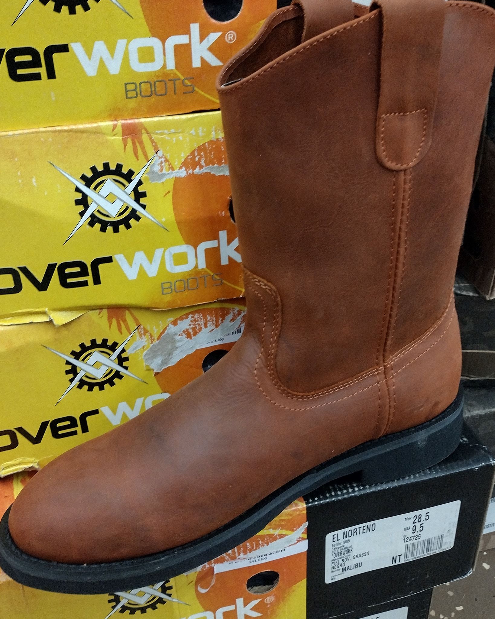 Brown leather work boot with black sole on a boxed display stand