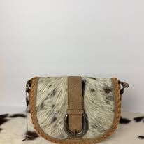 Small fur-trimmed crossbody bag with tan strap and brown trim on a patterned surface