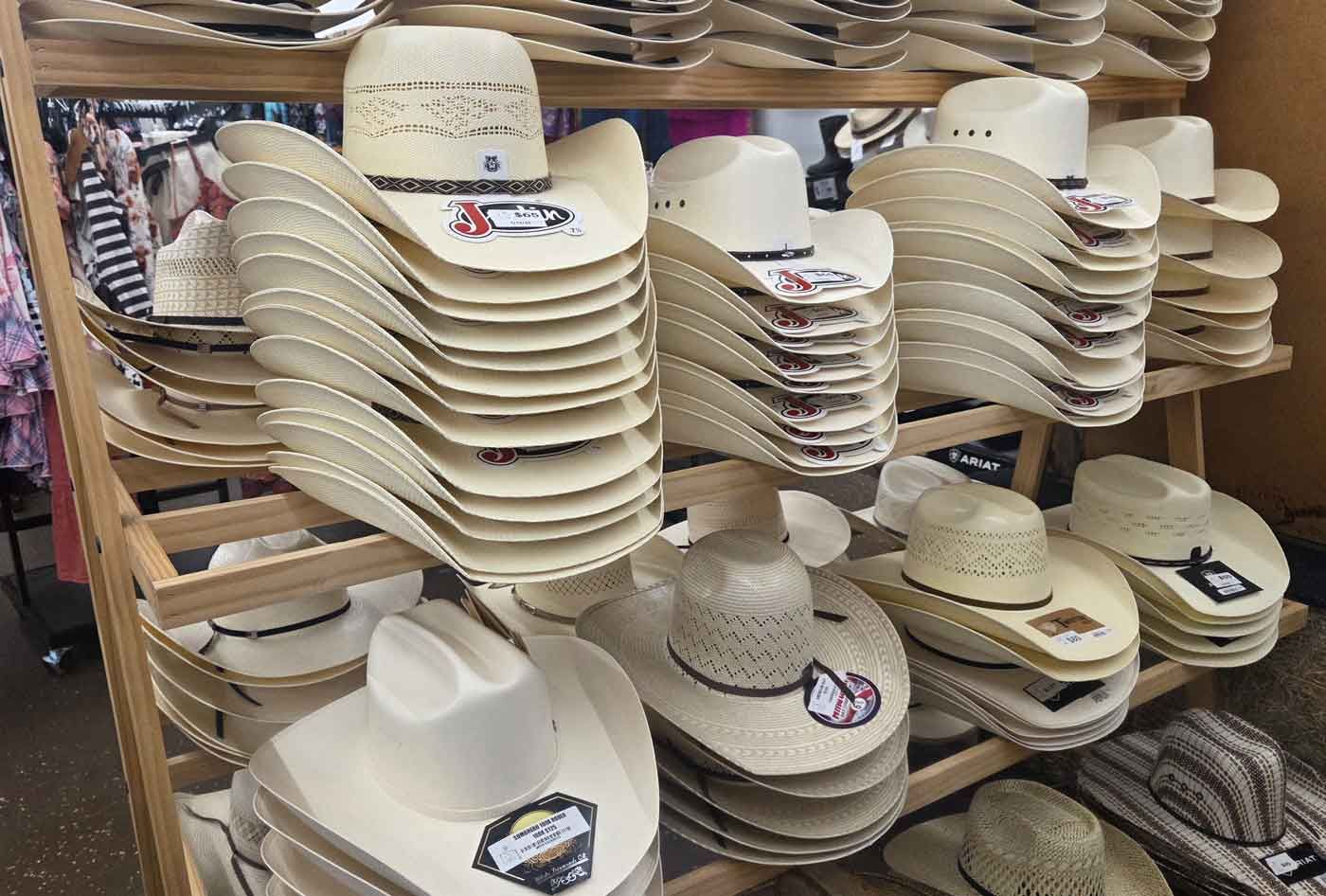 Shelves stacked with beige cowboy hats in a store display