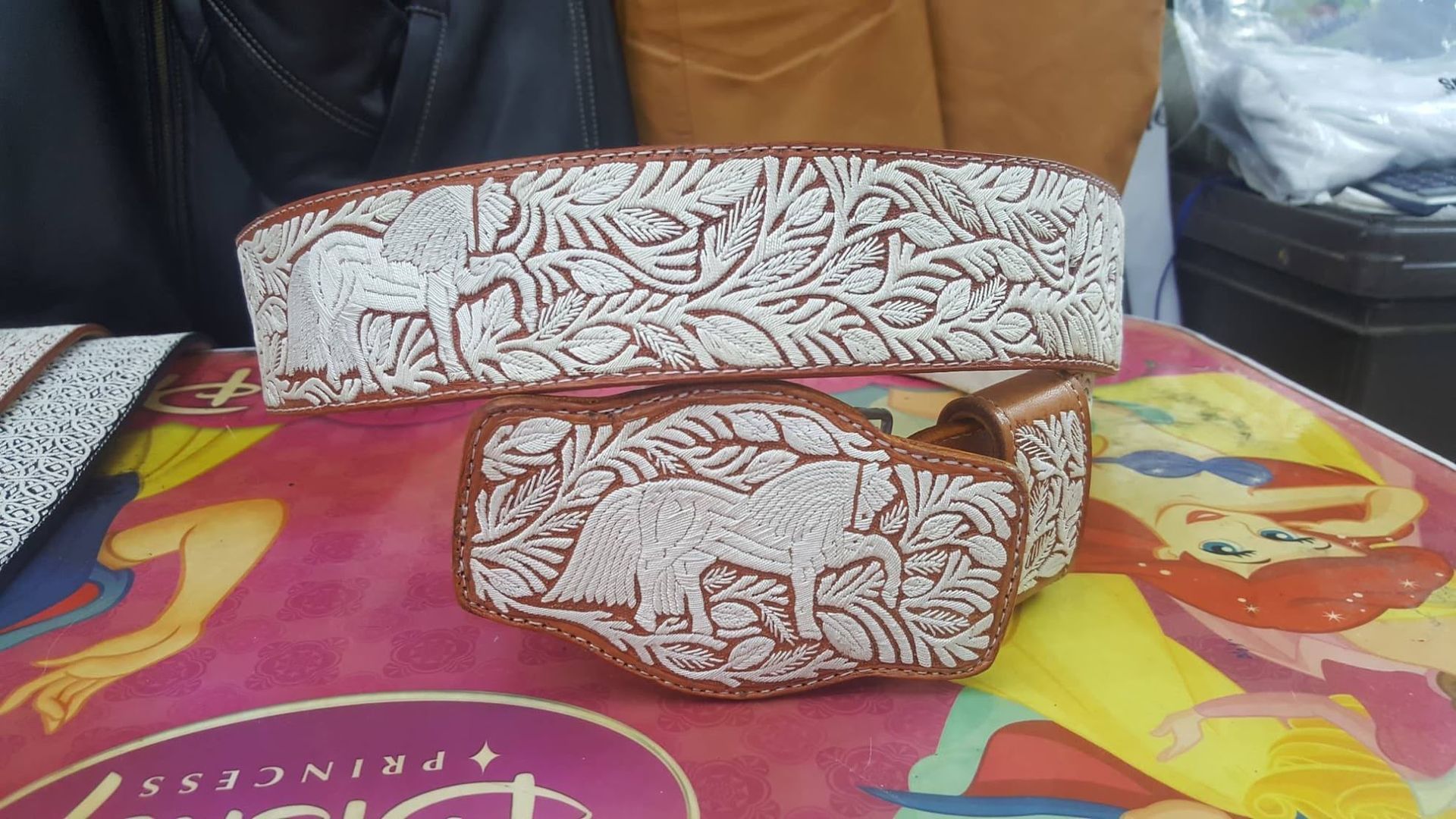 Two white patterned fabric storage boxes on a colorful tablecloth