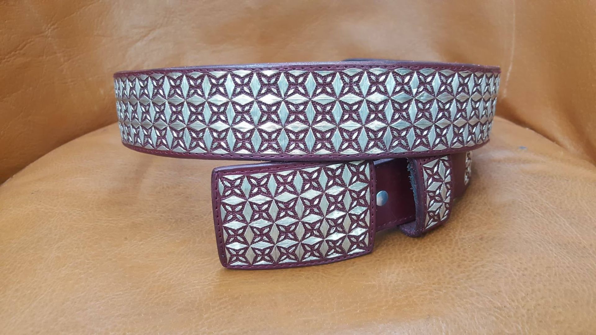 Patterned fabric dog collar and matching leash on a tan surface
