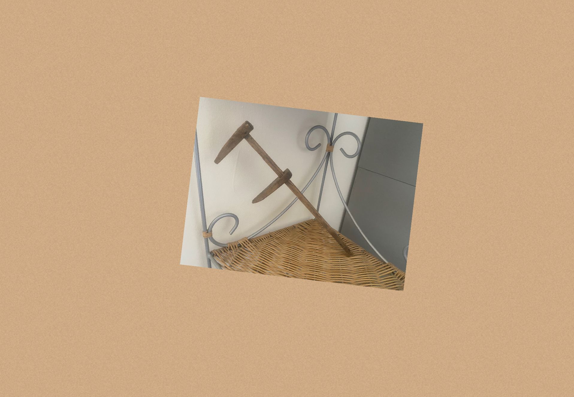 Piccola foto inclinata di utensili decorativi in ​​metallo e paglia su uno sfondo beige.
