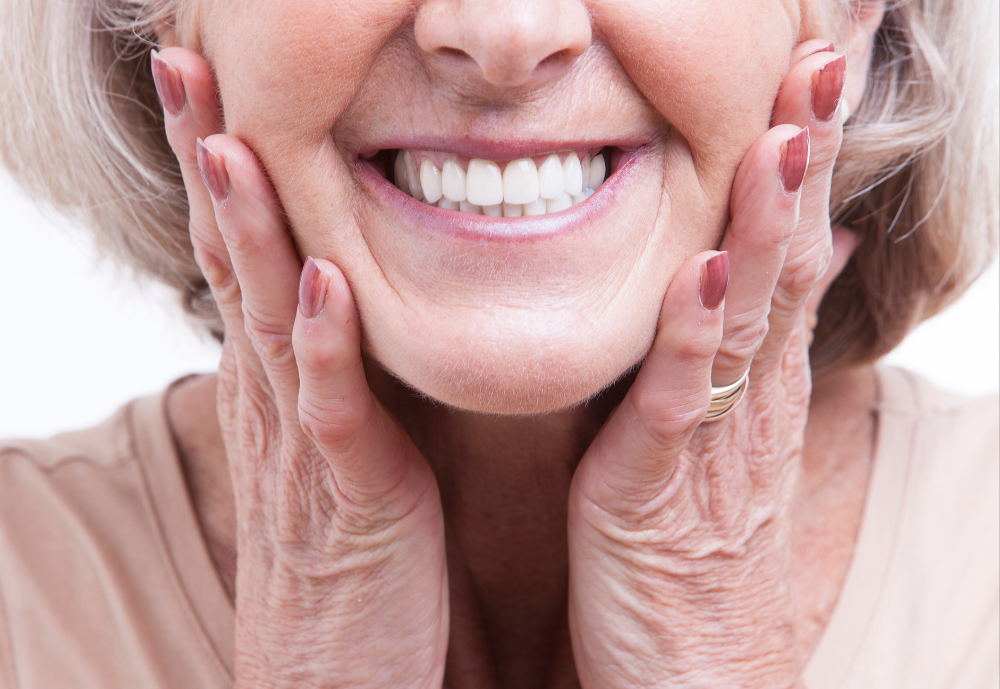 Woman demonstrating areas for cosmetic injections: frown lines, crow's feet, jawline.