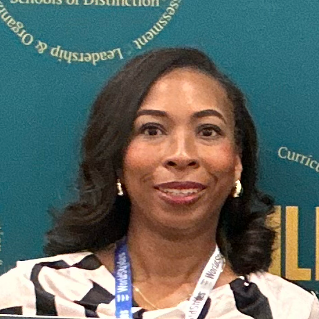 Woman smiling, wearing a patterned top, badge. Background is teal with text.
