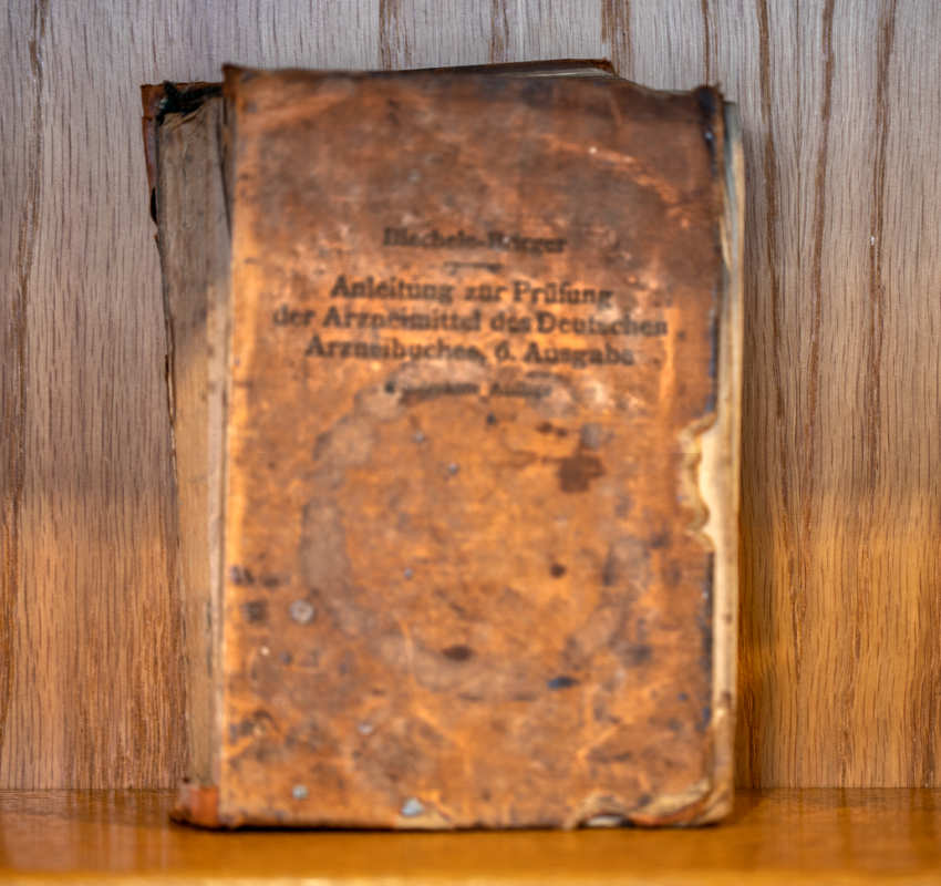 An old, weathered book with a brown cover, titled