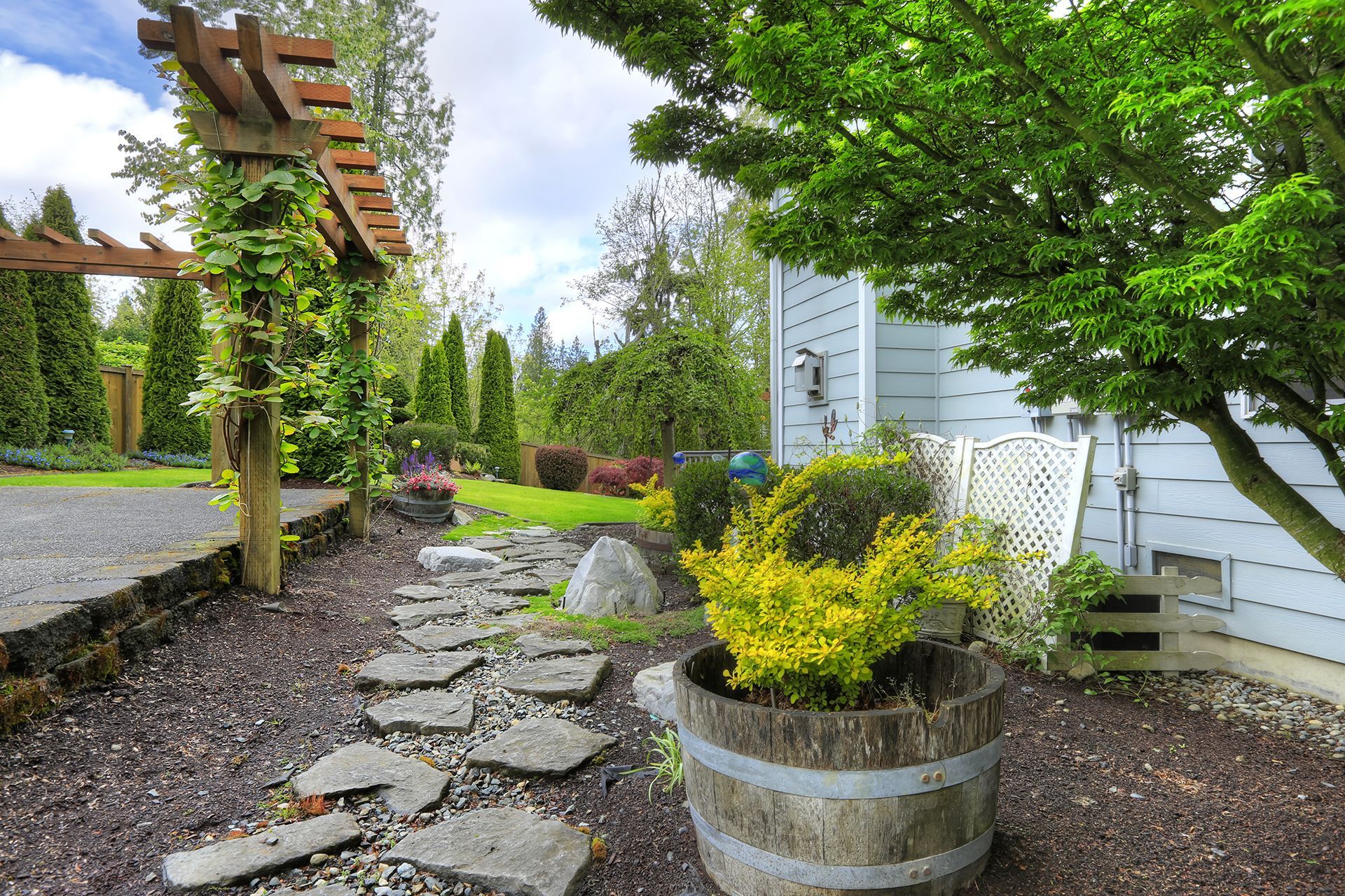 A wooden barrel is sitting in the middle of a garden.
