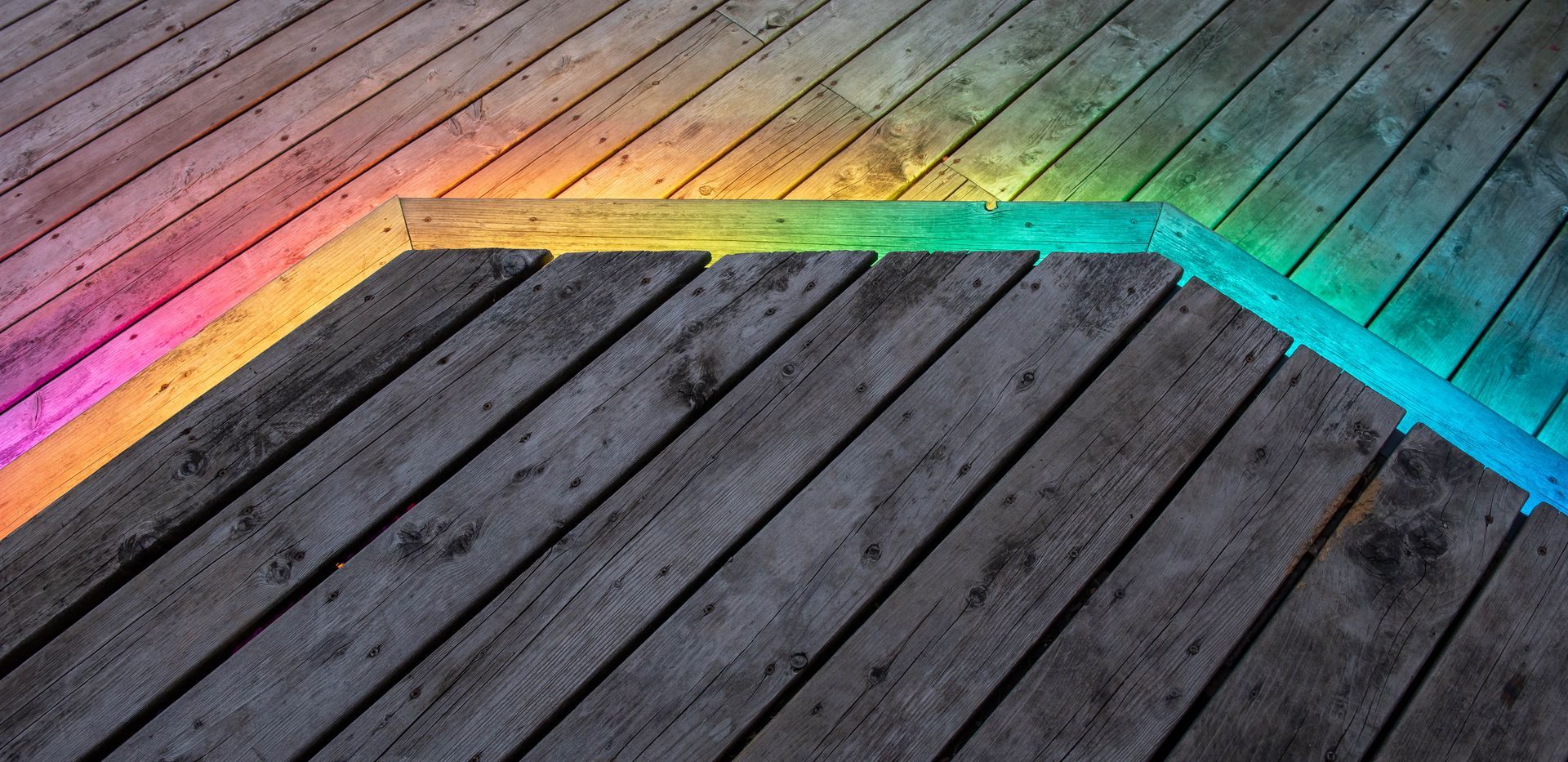 A wooden deck with a rainbow in the middle of it.