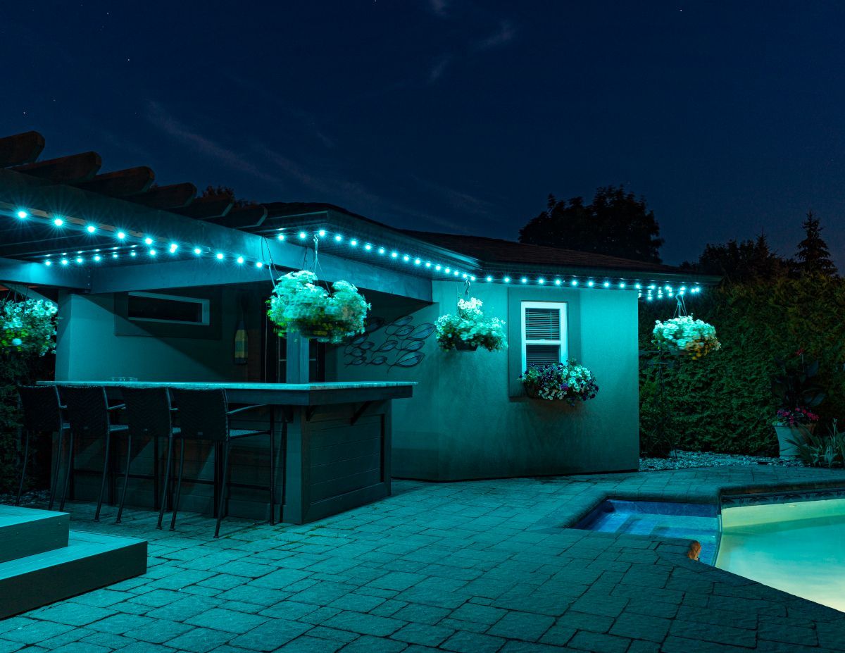 A patio with a bar and a pool at night