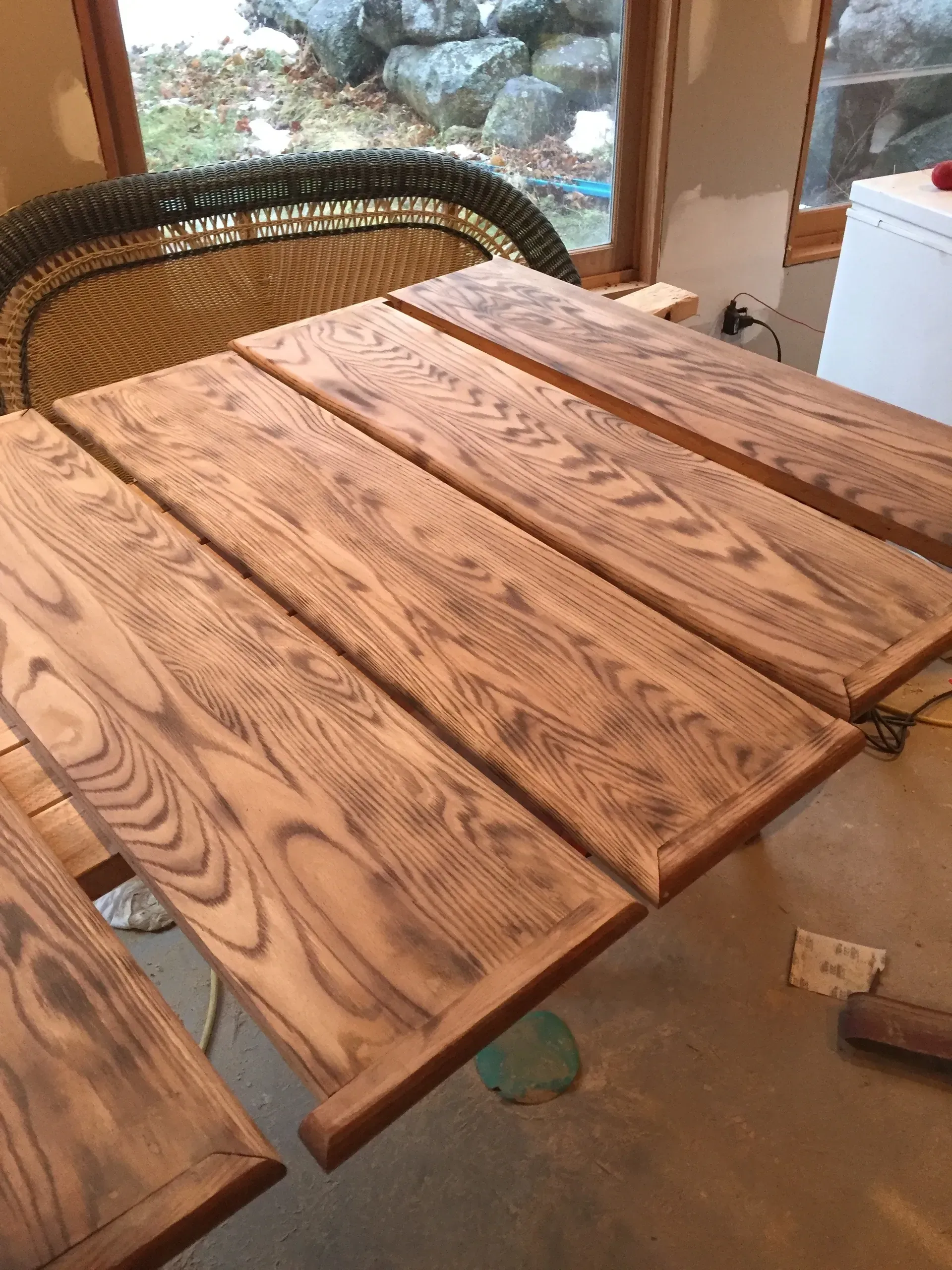 Wooden planks stained in brown, arranged on a table, likely for a tabletop.