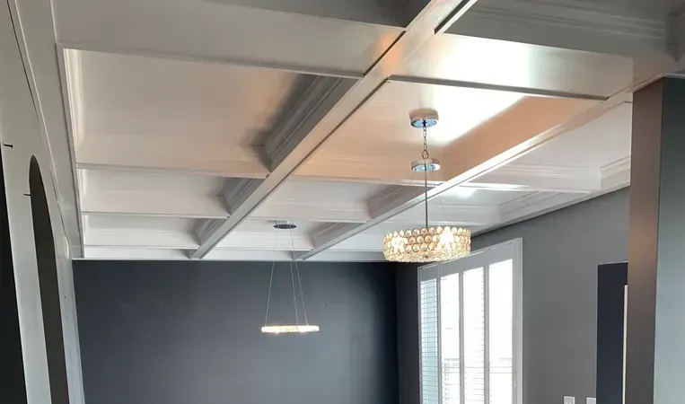 Modern room with metallic ceiling, gray walls, pendant lights, and large windows.